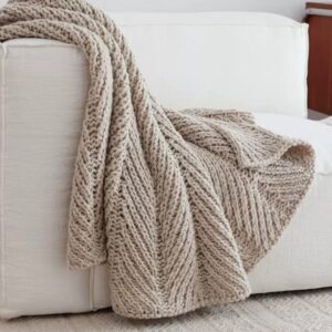 Knitted throw blanket folded on a bed